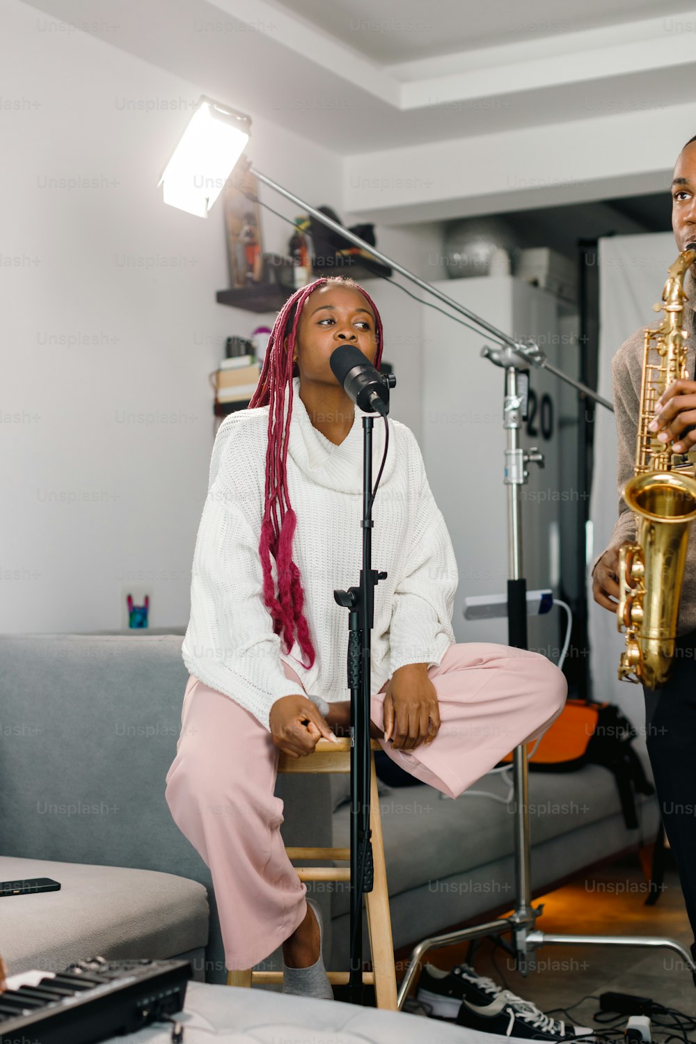 a woman sitting on a chair next to a man with a saxophone