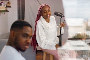 a man and a woman sitting in front of a microphone