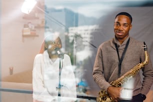 a man standing next to a woman holding a saxophone