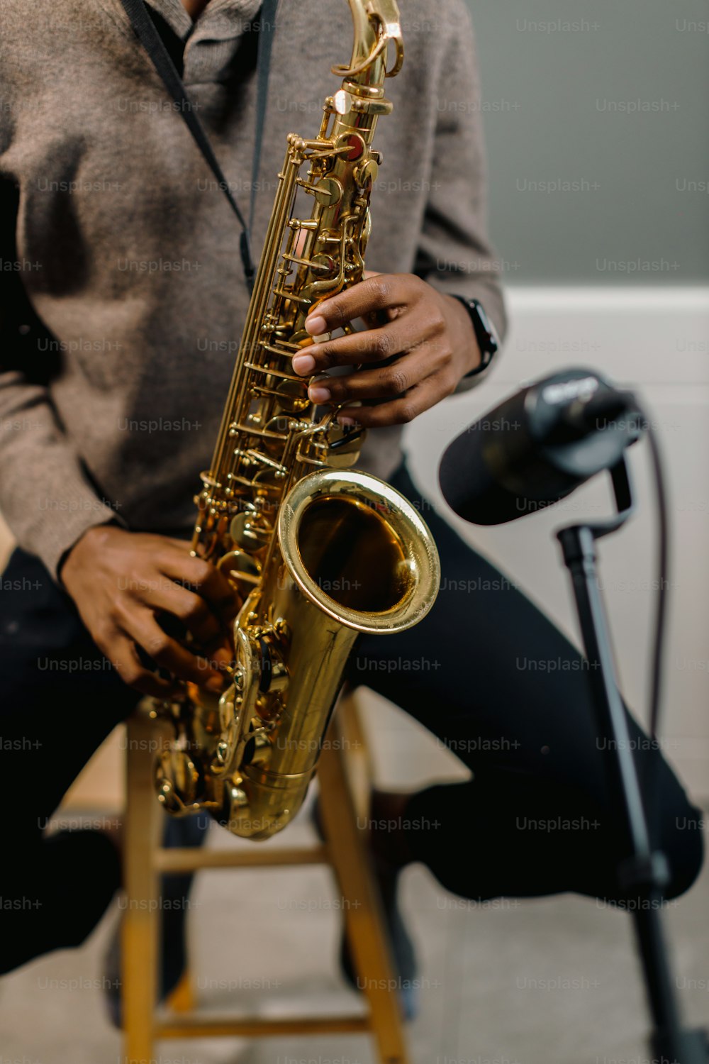Un homme assis sur un tabouret tenant un saxophone