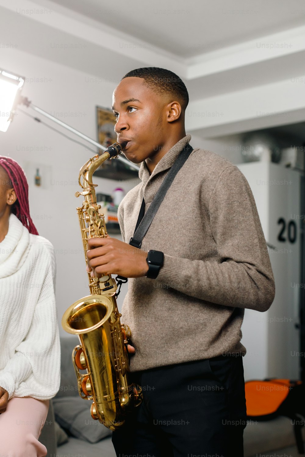 a man playing a saxophone next to a woman