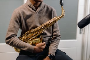 Un homme tenant un saxophone devant un micro