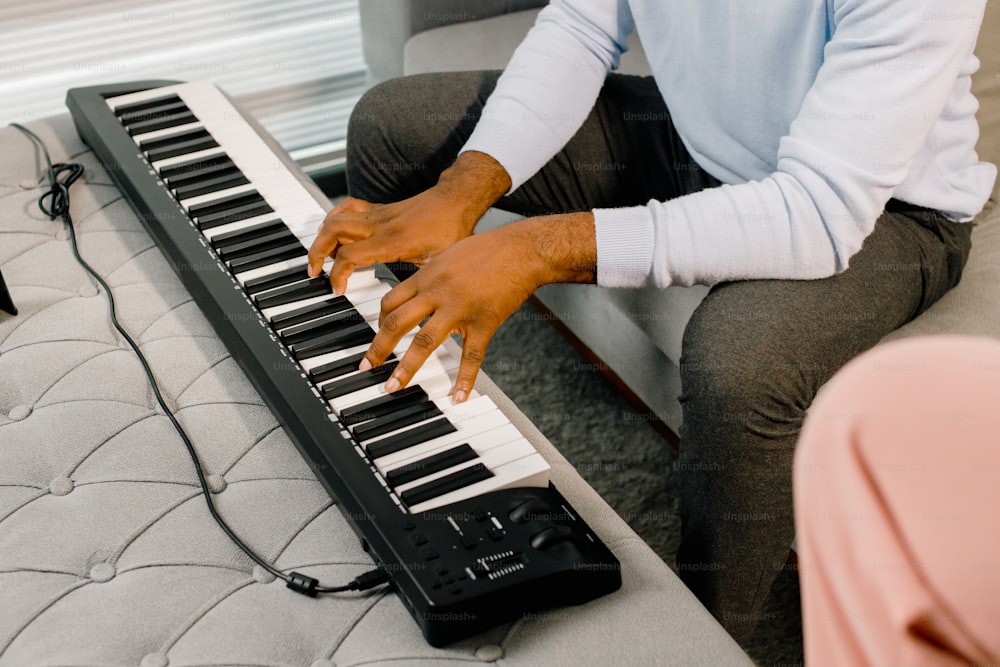 a man sitting on a couch playing a keyboard