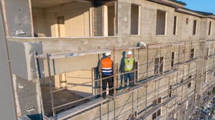 a couple of men standing next to each other on a scaffold