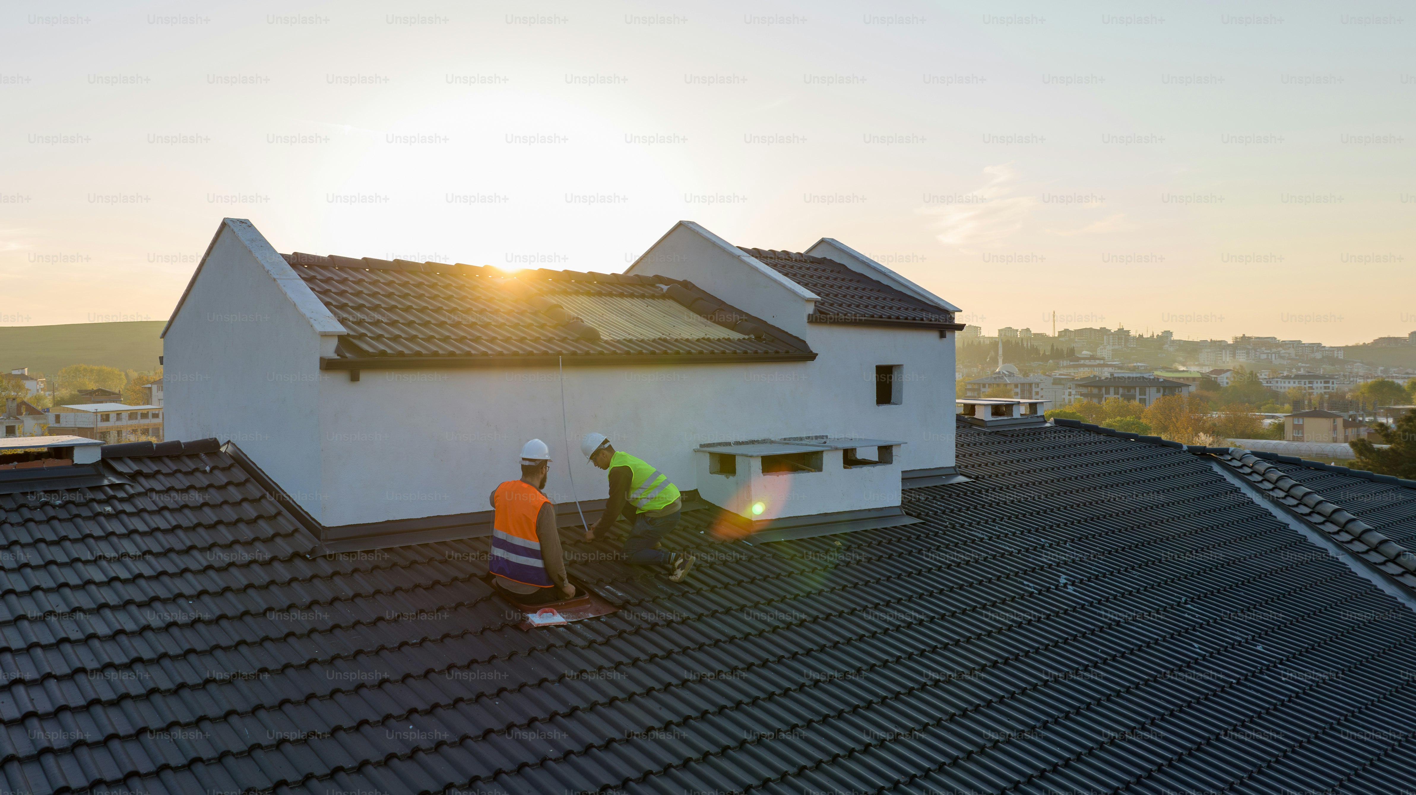 a couple of men standing on top of a roof