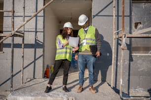 a man and a woman in hard hats and safety vests