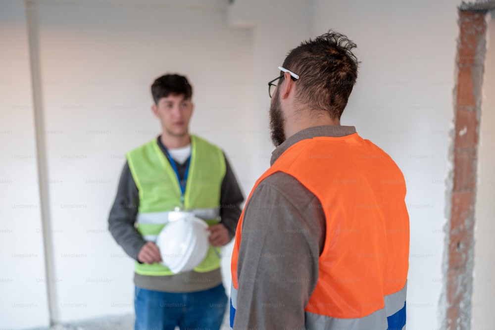 two men in safety vests standing next to each other