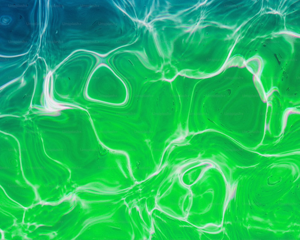 a green and blue background with some water