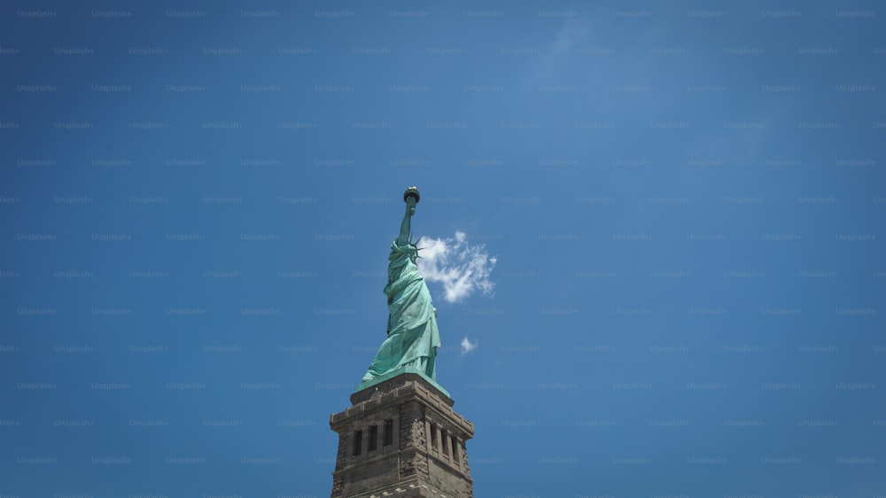 the top of the statue of liberty against a blue sky