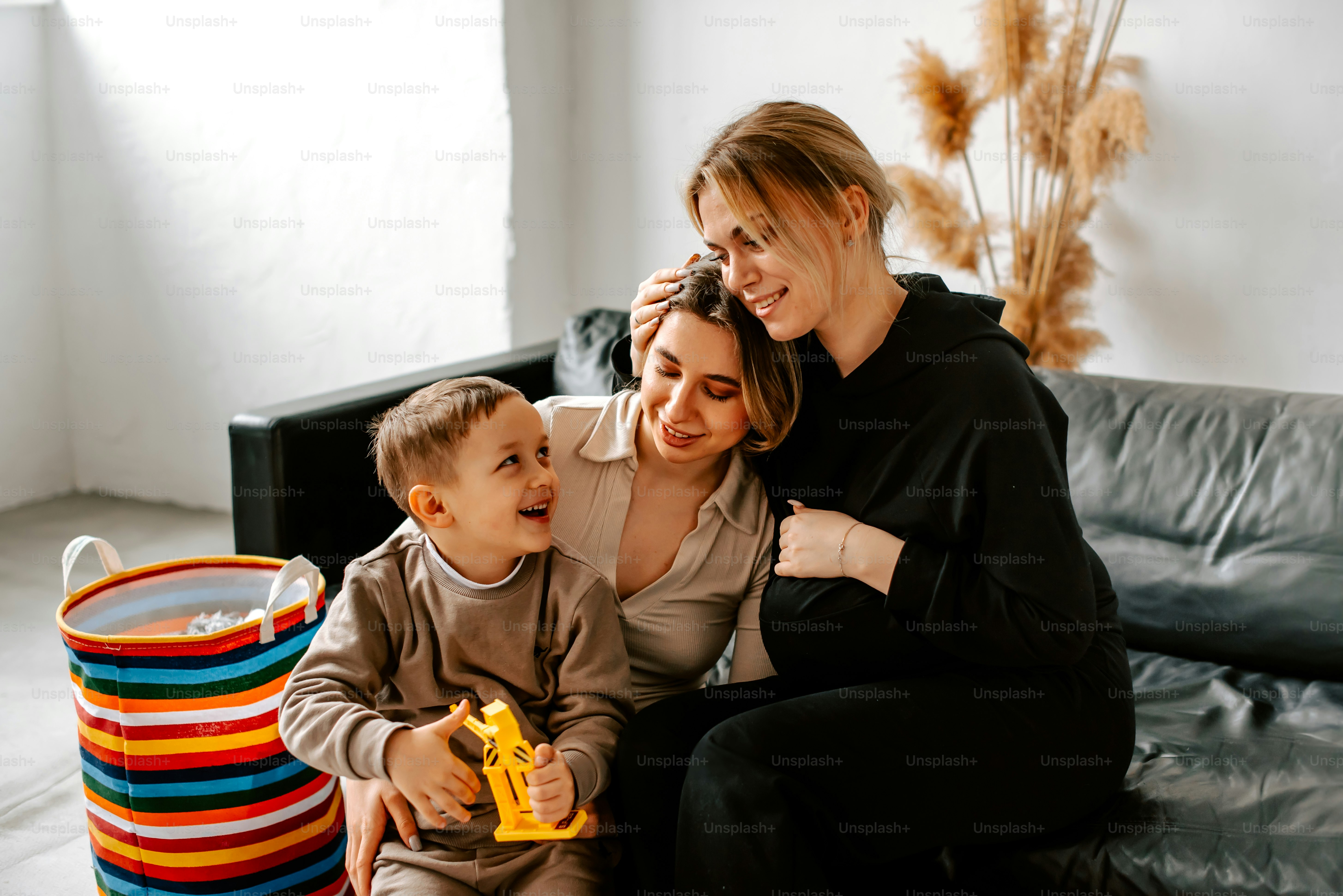 Une femme et deux enfants assis sur un canapé