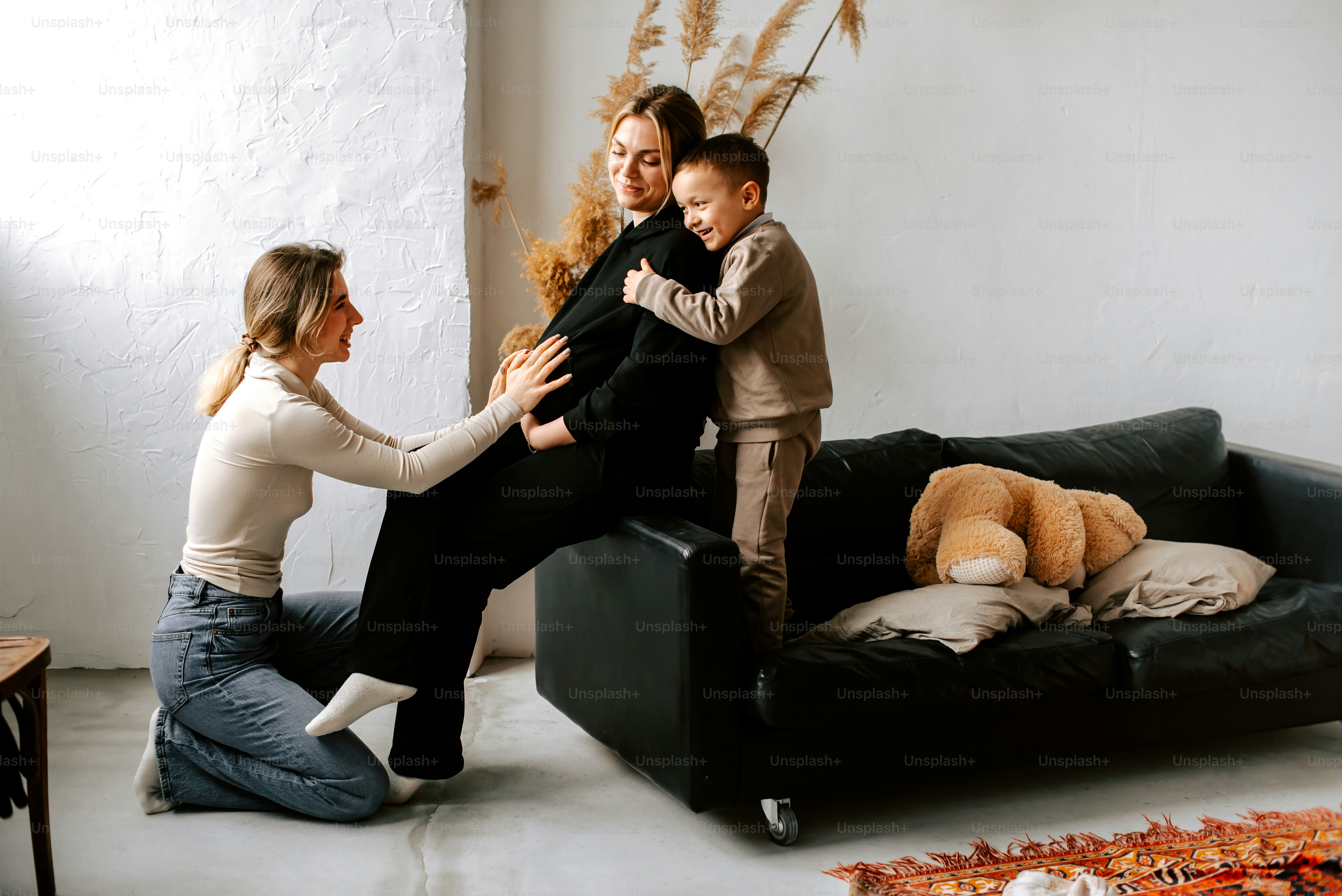 Dos mujeres y un niño están sentados en un sofá
