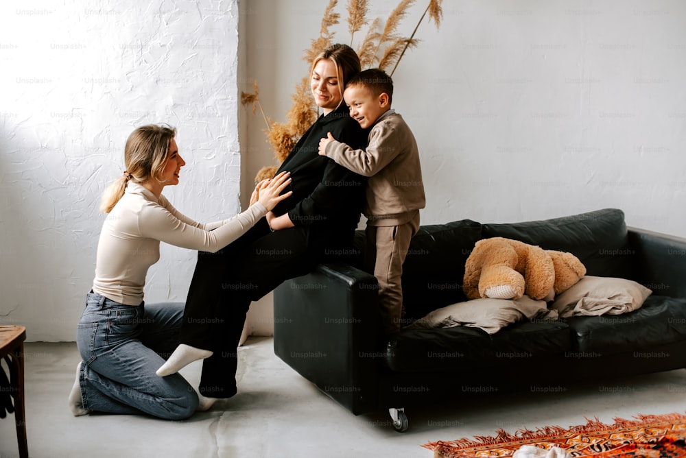two women and a boy are sitting on a couch