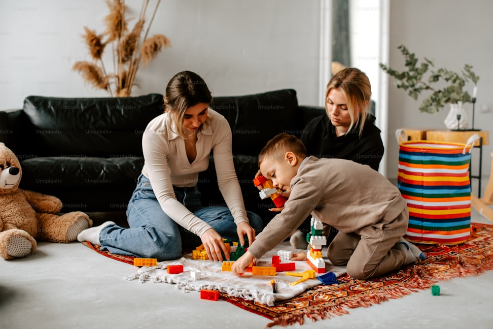 a woman and a child playing with blocks on the floor