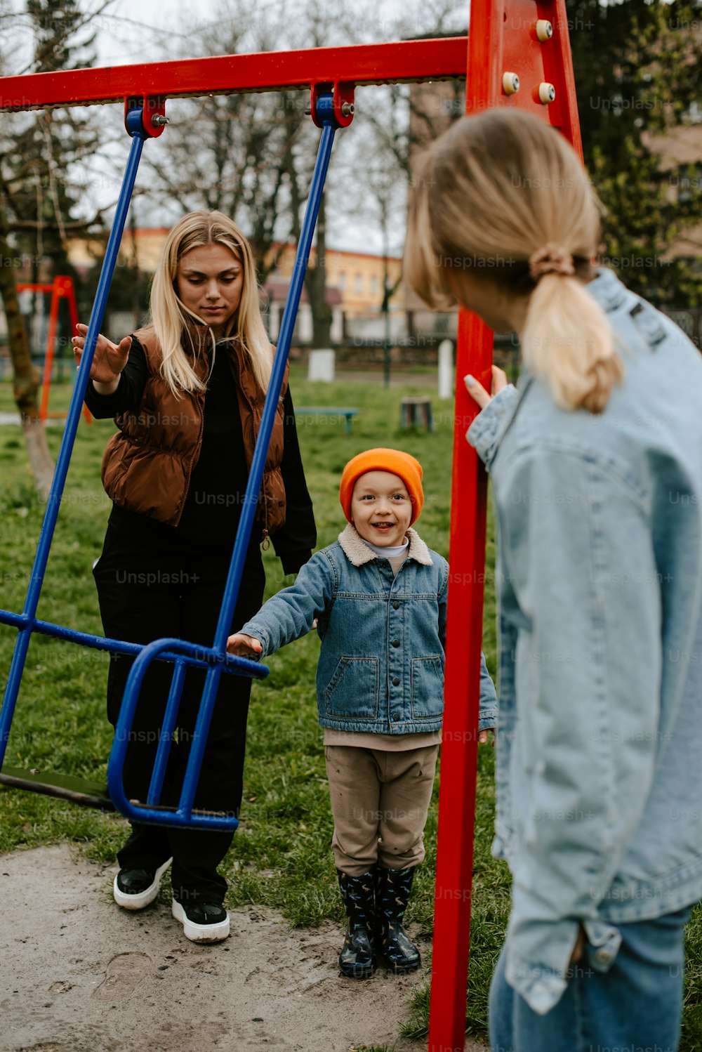 a woman and a child playing on a swing set