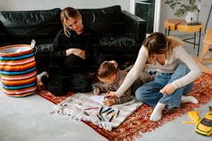 a woman and a child are sitting on a rug