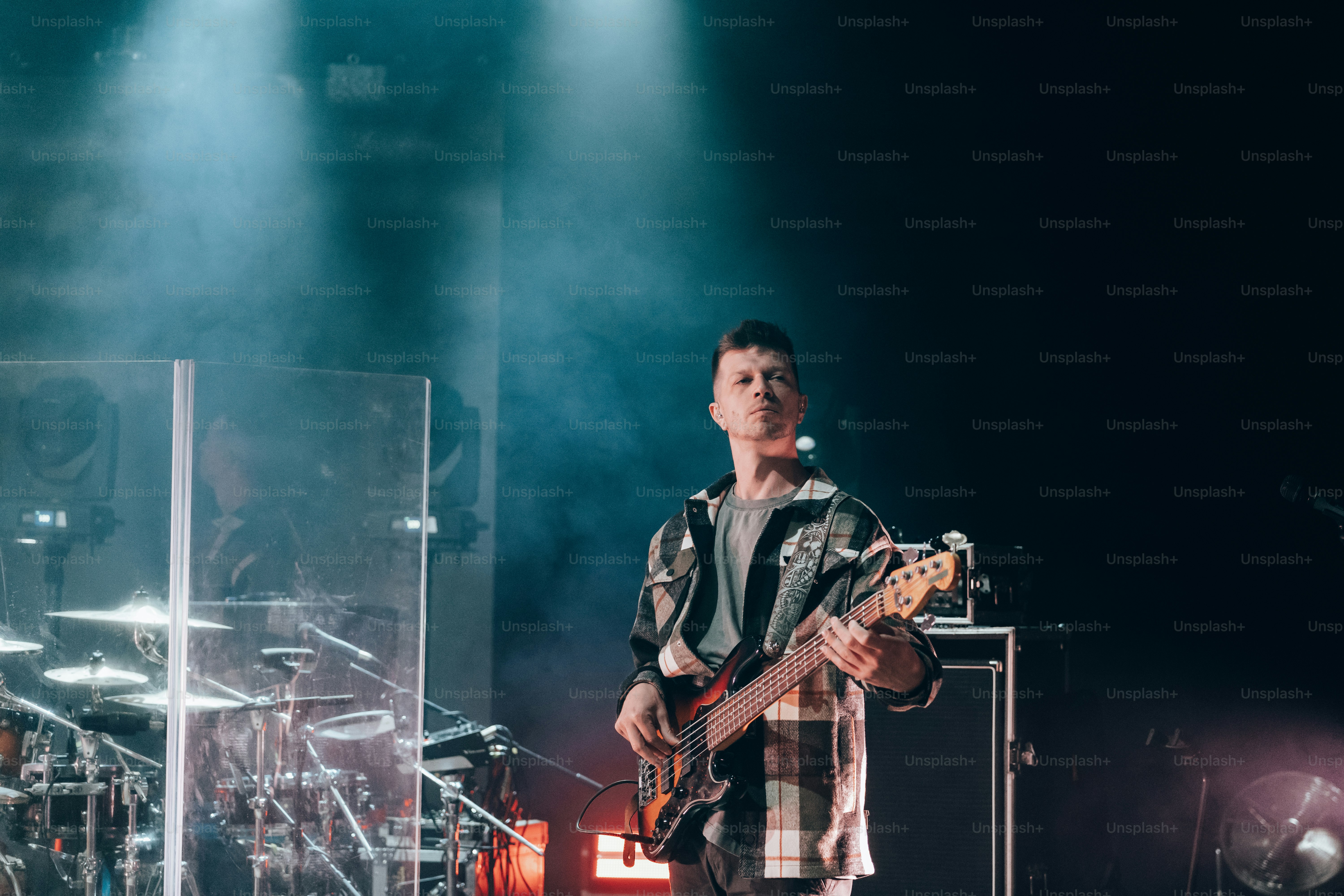 a man standing on a stage with a guitar