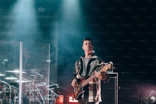 Un uomo in piedi su un palco con una chitarra
