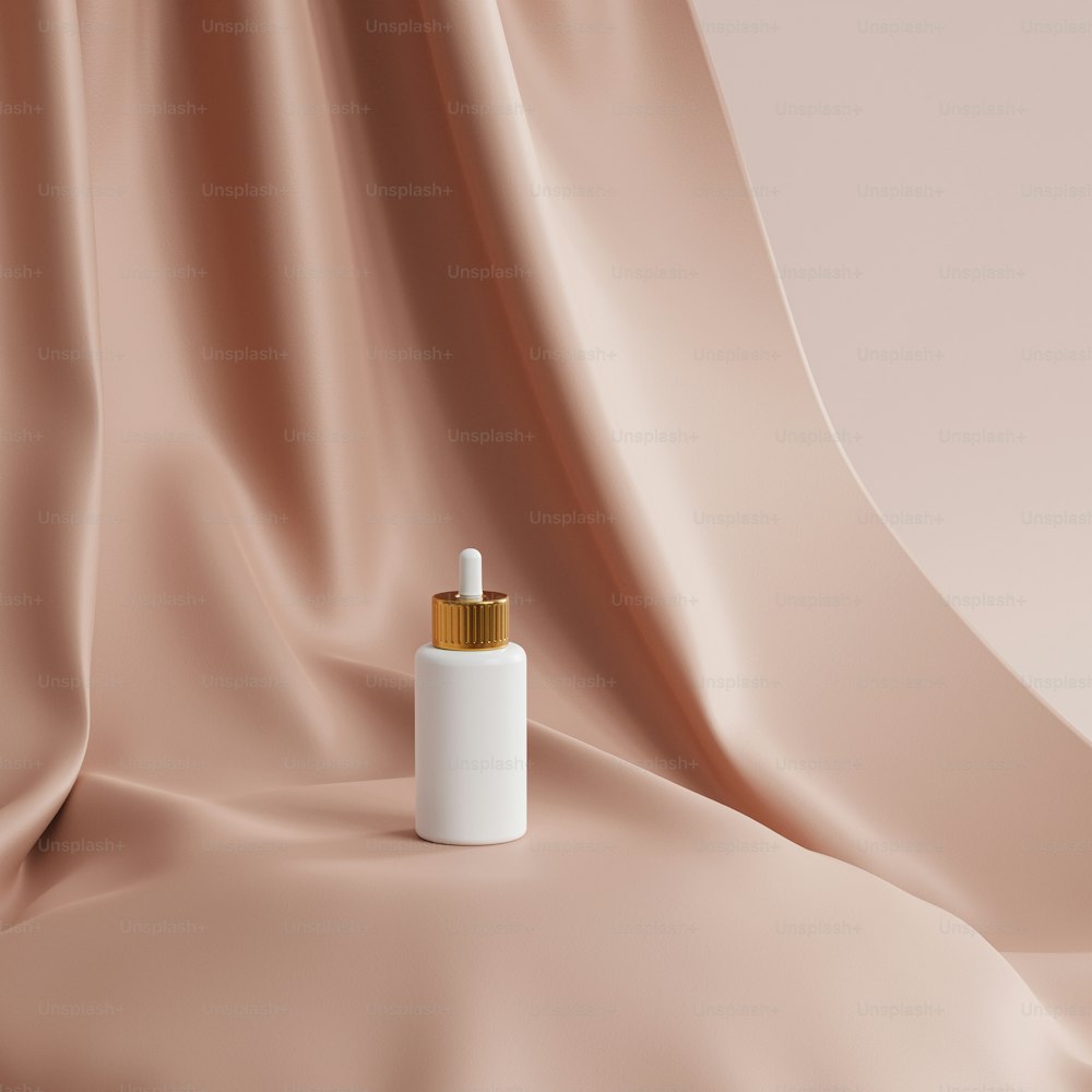 una botella blanca con una tapa dorada sobre un paño rosa