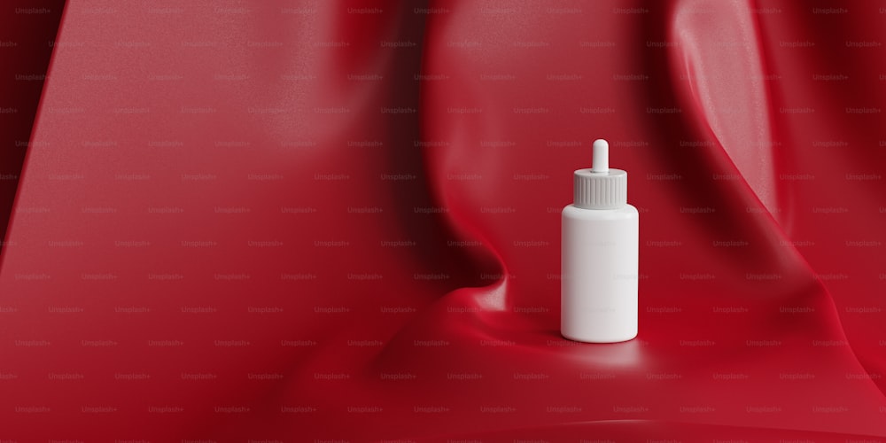 a white bottle with a dropper on a red cloth