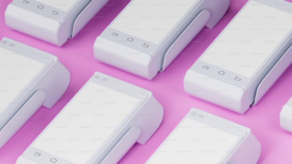 um grupo de dispositivos eletrônicos sentados em cima de uma superfície rosa