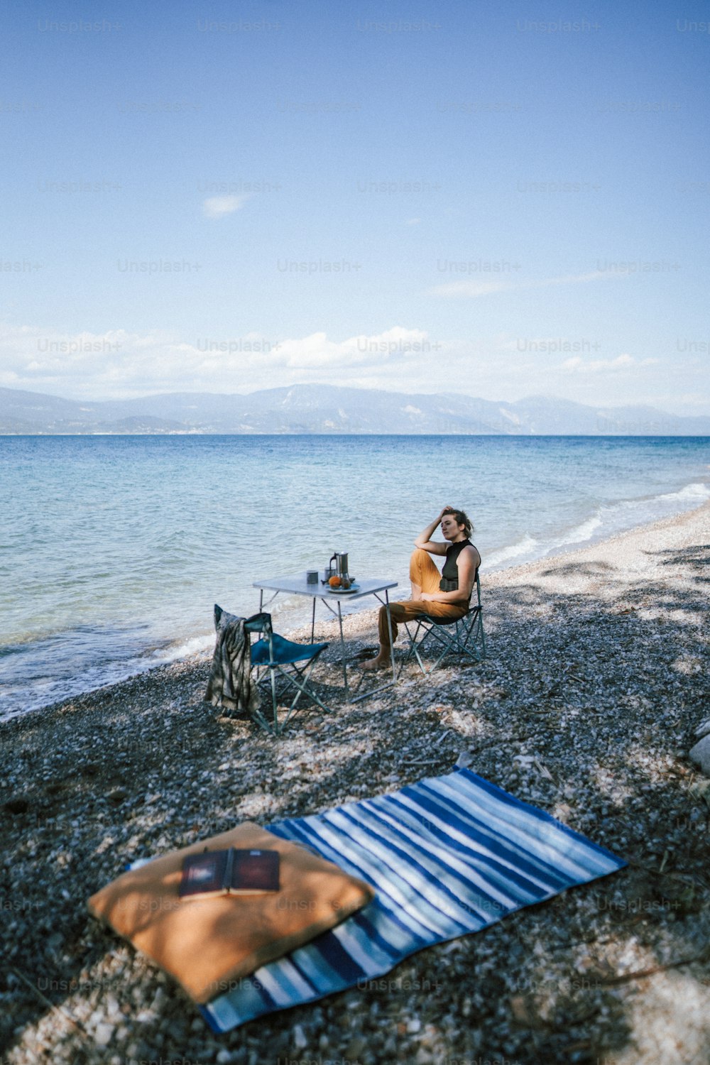 um homem sentado em uma cadeira na praia
