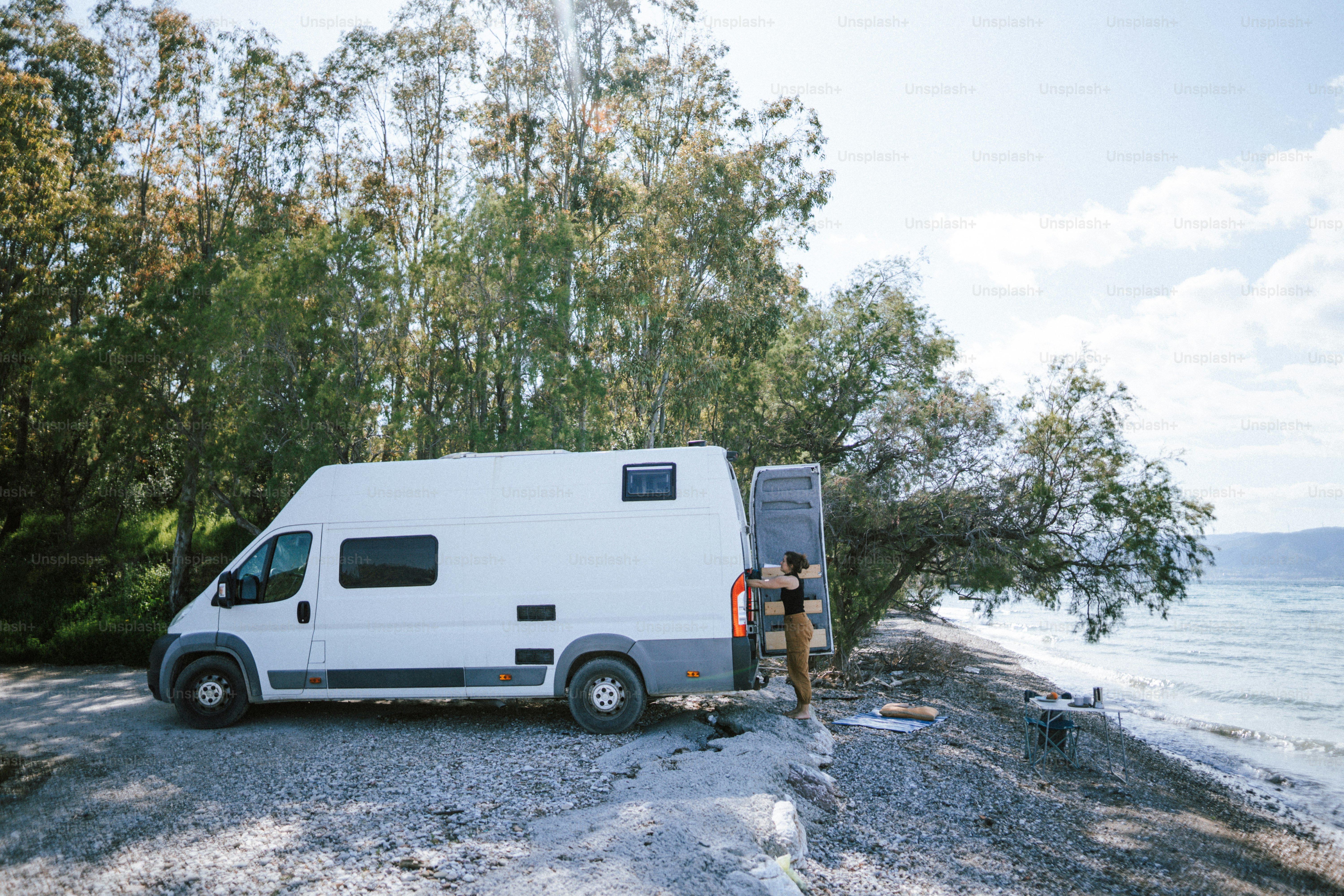 a man standing next to a white van on a beach
