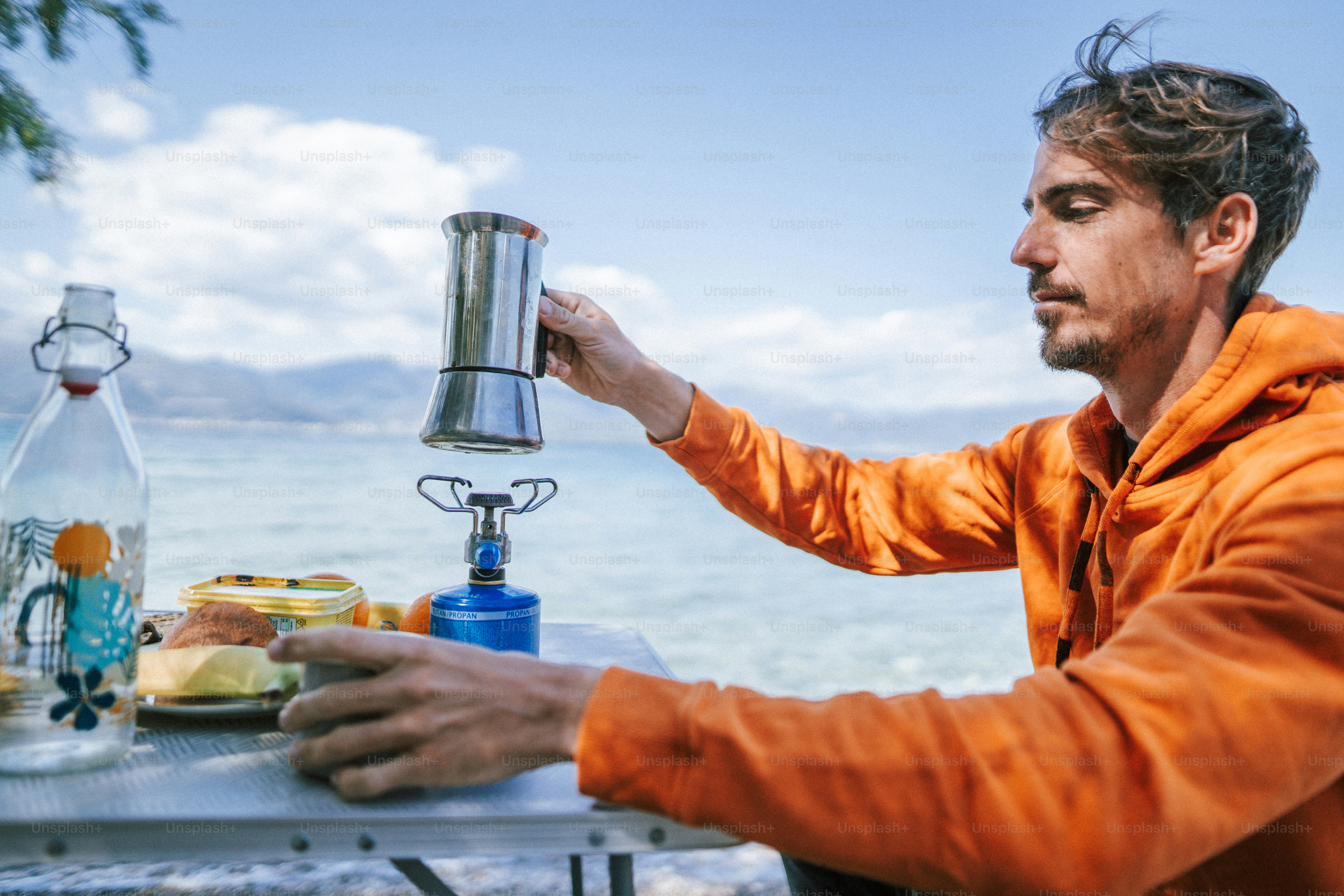 Un uomo seduto a un tavolo con una bottiglia d'acqua