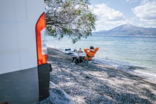 a man sitting at a table next to the ocean