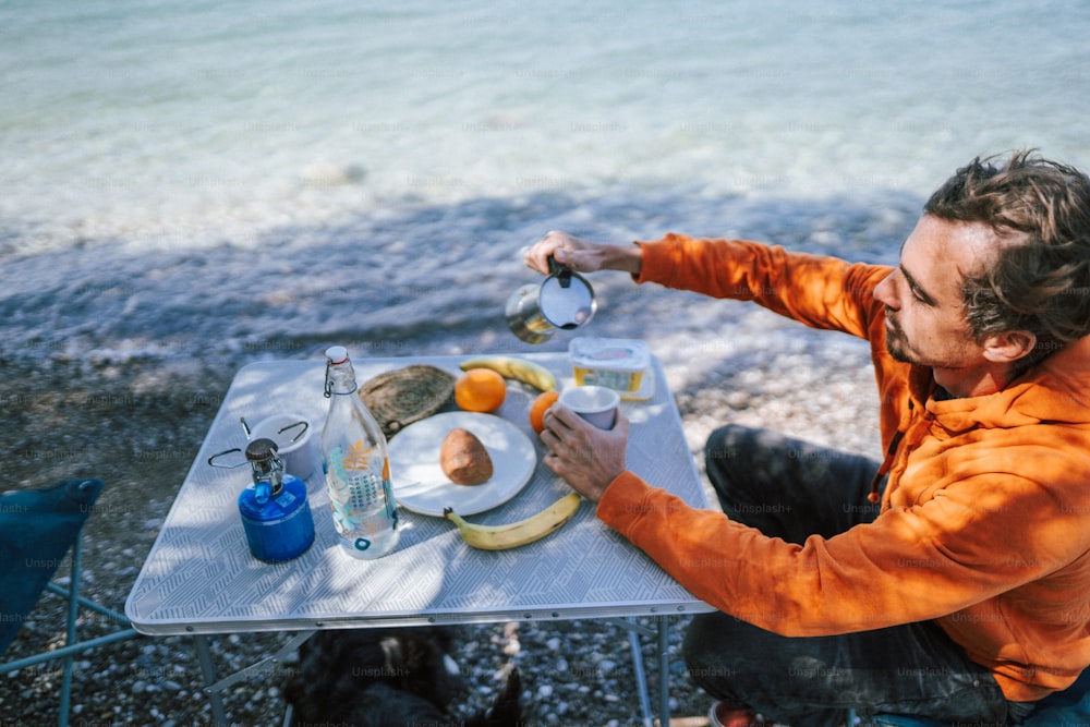 a man sitting at a table with a plate of food