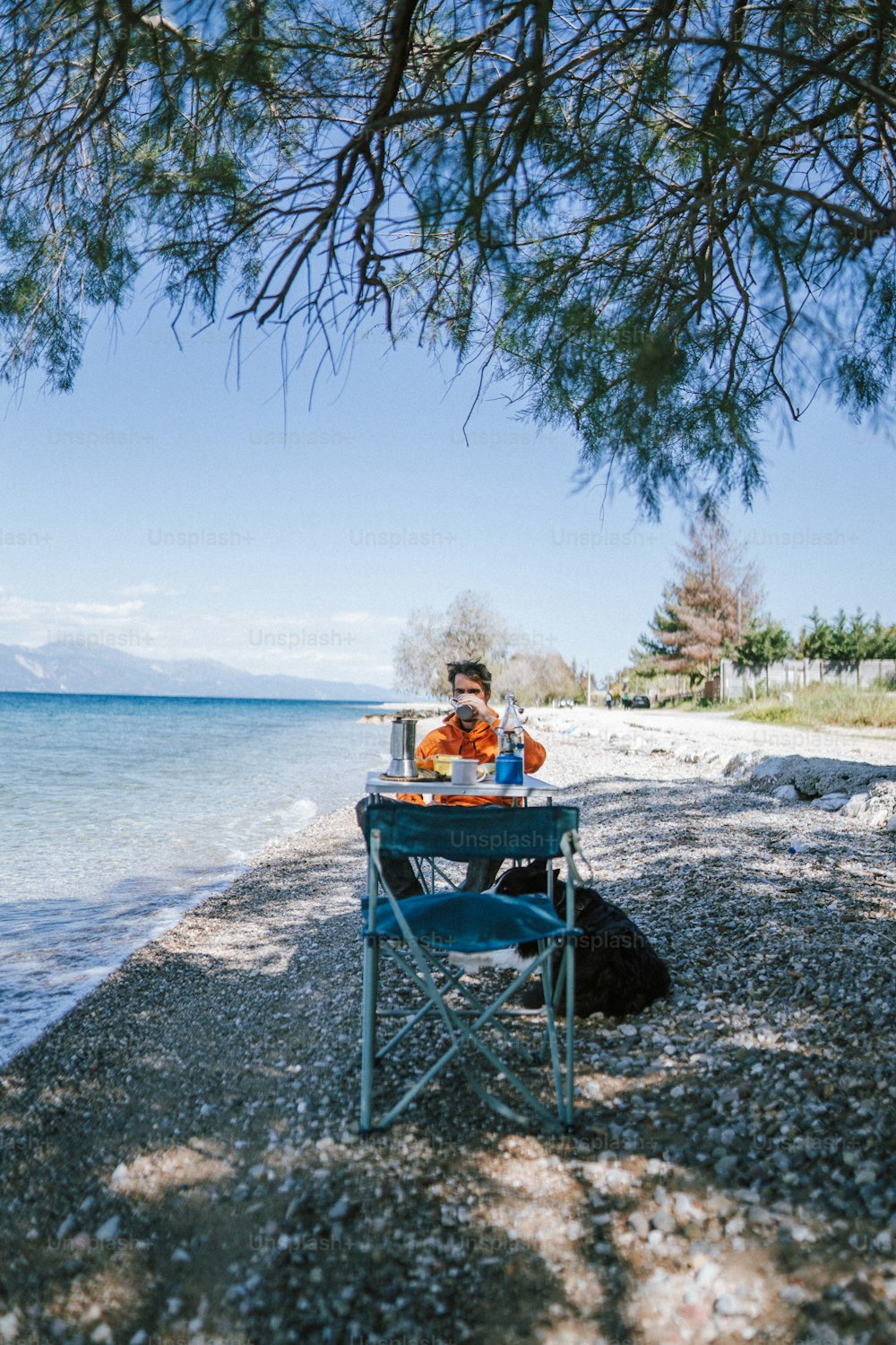 a man sitting at a table on the beach