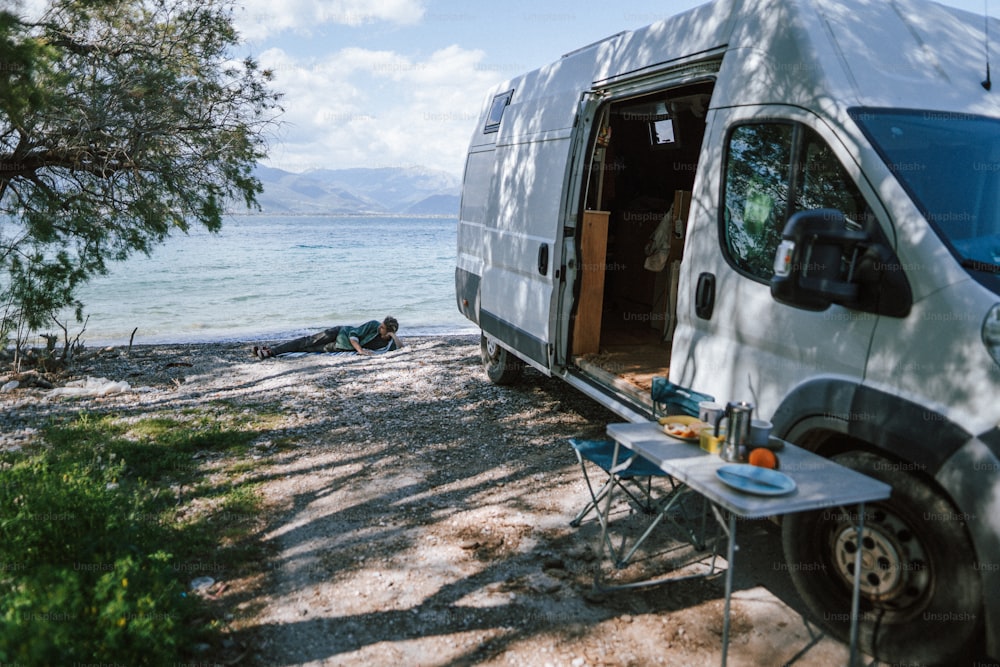 a camper van parked on a beach next to the ocean