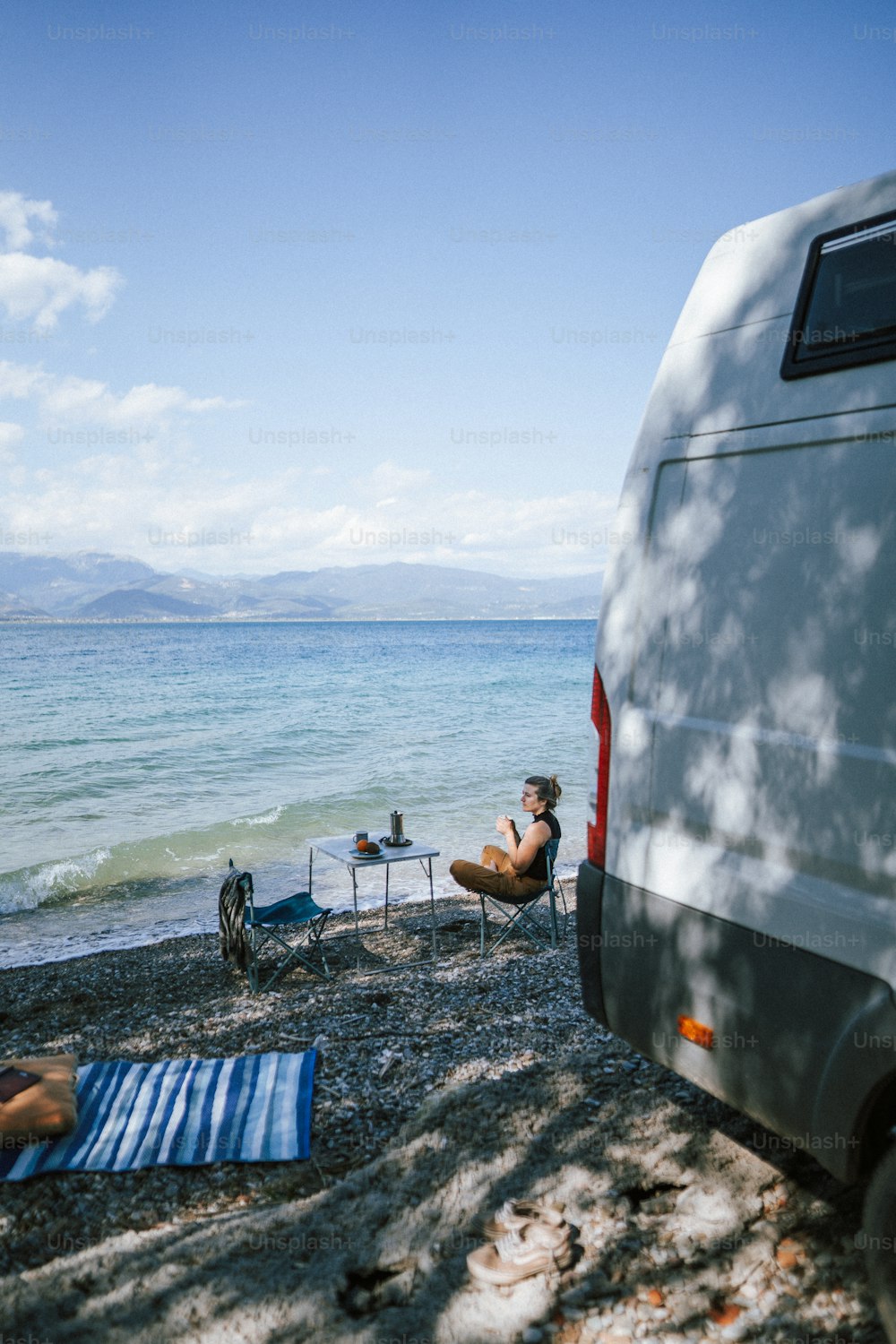 a van parked on a beach next to the ocean