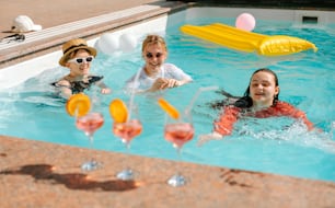 a group of people in a pool with drinks