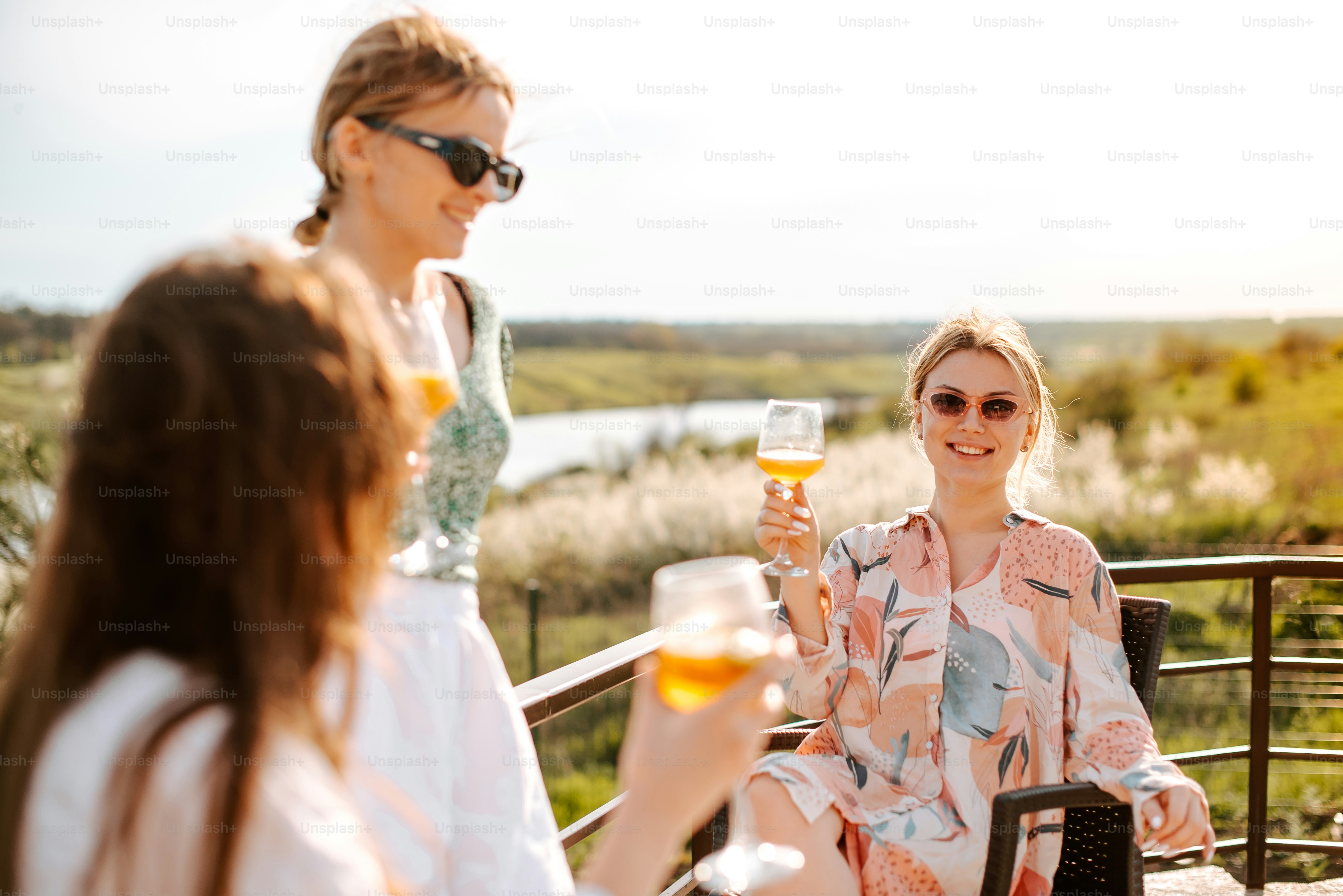 Un grupo de mujeres sentadas una alrededor de la otra sosteniendo copas de vino