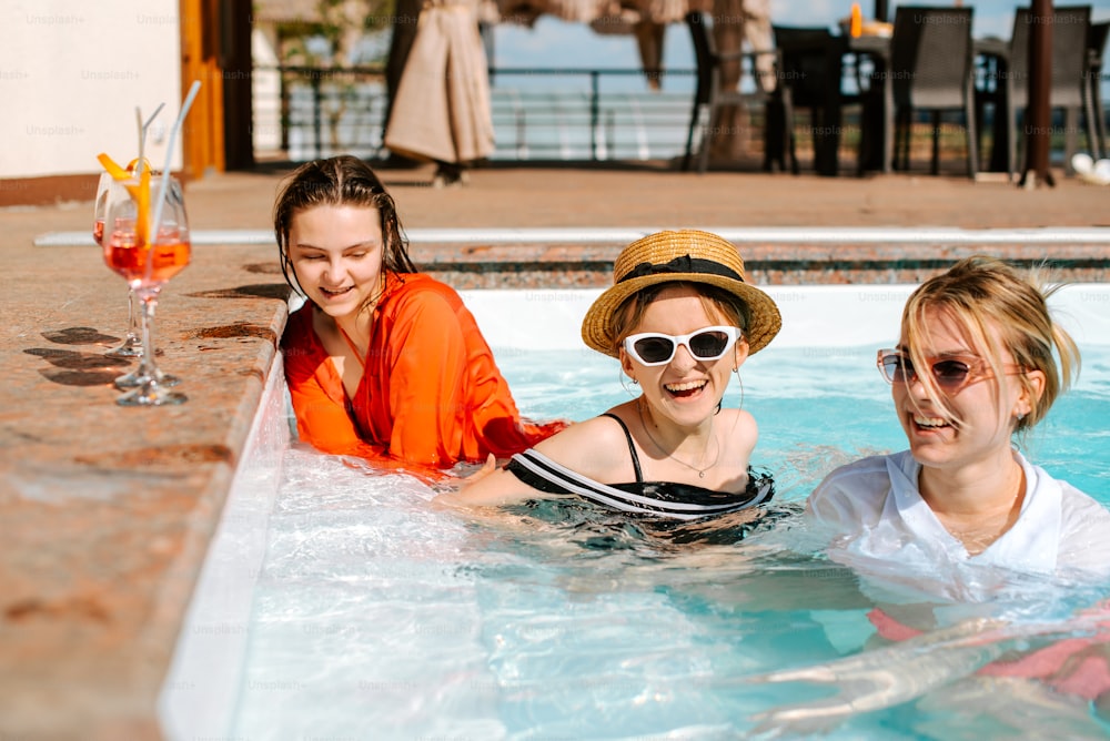 Un grupo de mujeres sentadas en una piscina una al lado de la otra