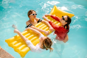 um grupo de pessoas flutuando em uma piscina em jangadas infláveis