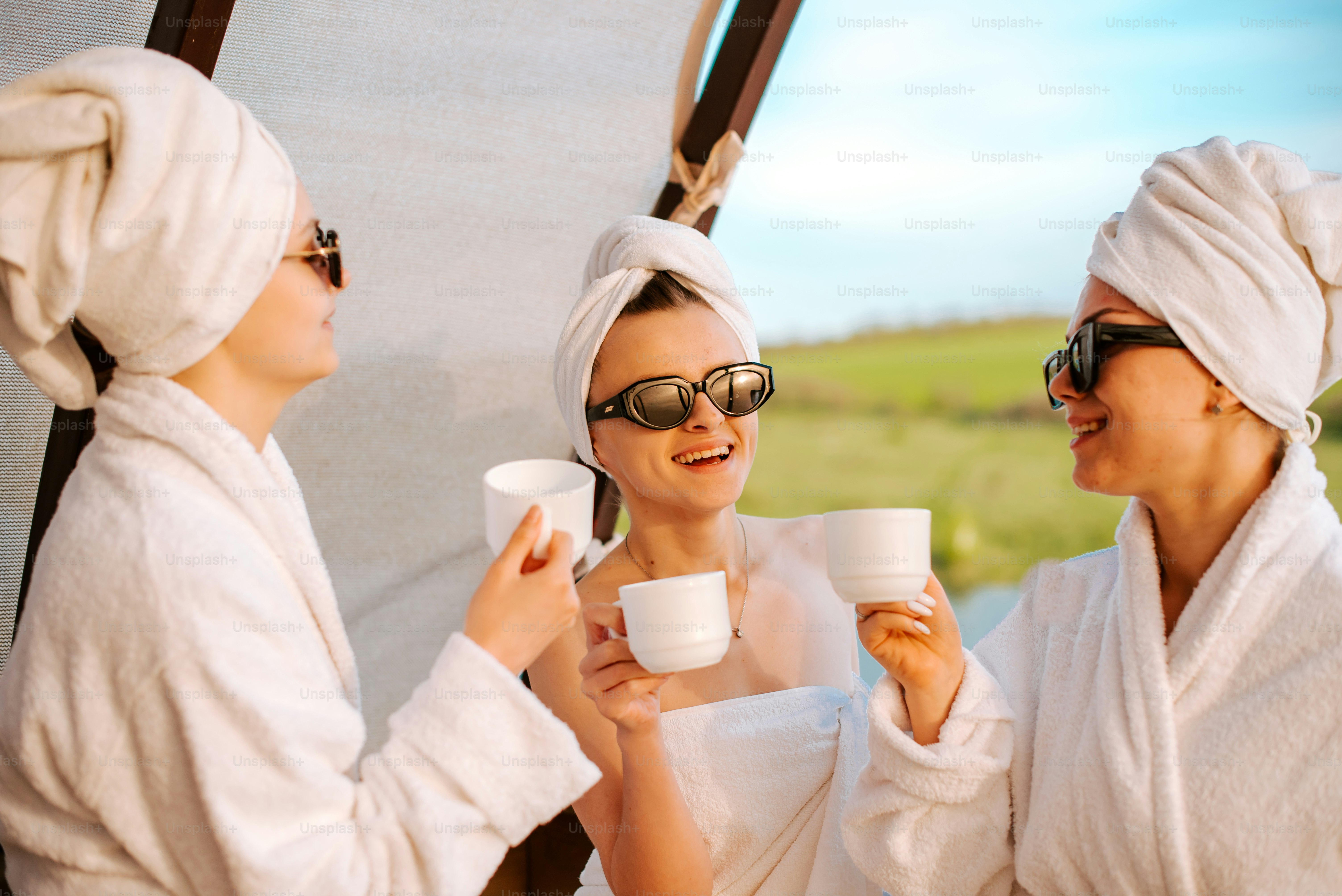 a couple of women standing next to each other holding cups