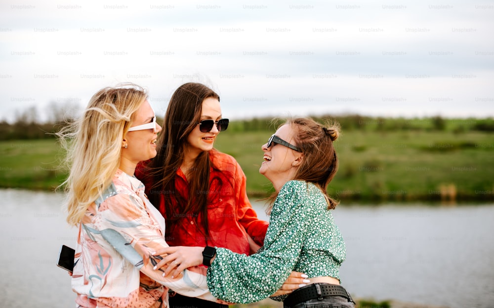 Eine Gruppe von Frauen, die nebeneinander in der Nähe eines Sees stehen