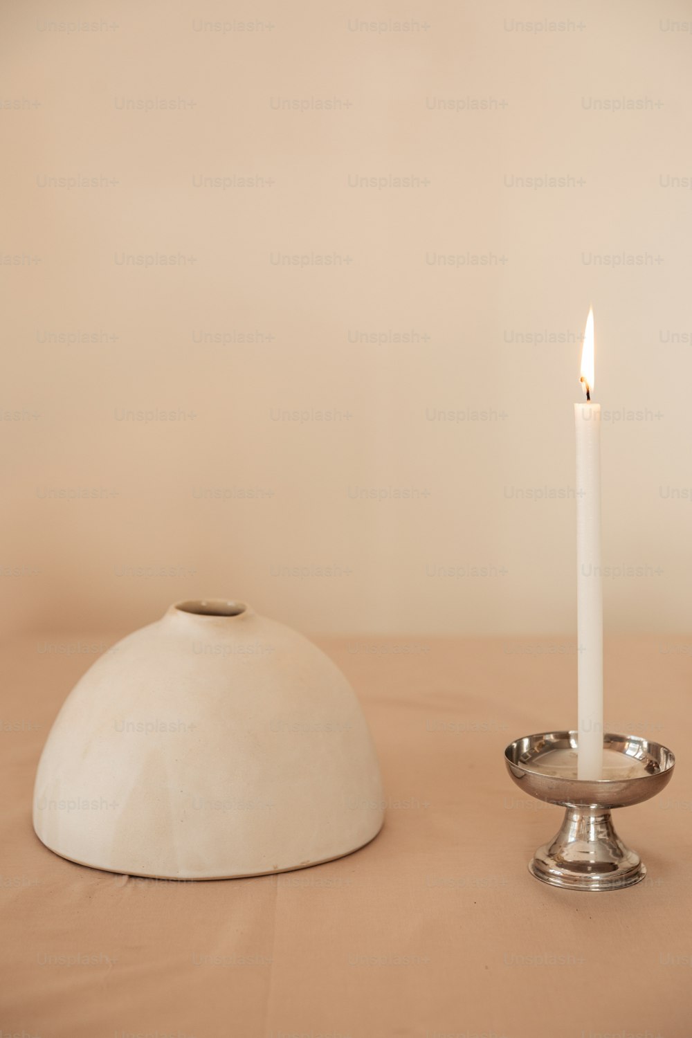 una candela bianca seduta sopra un tavolo