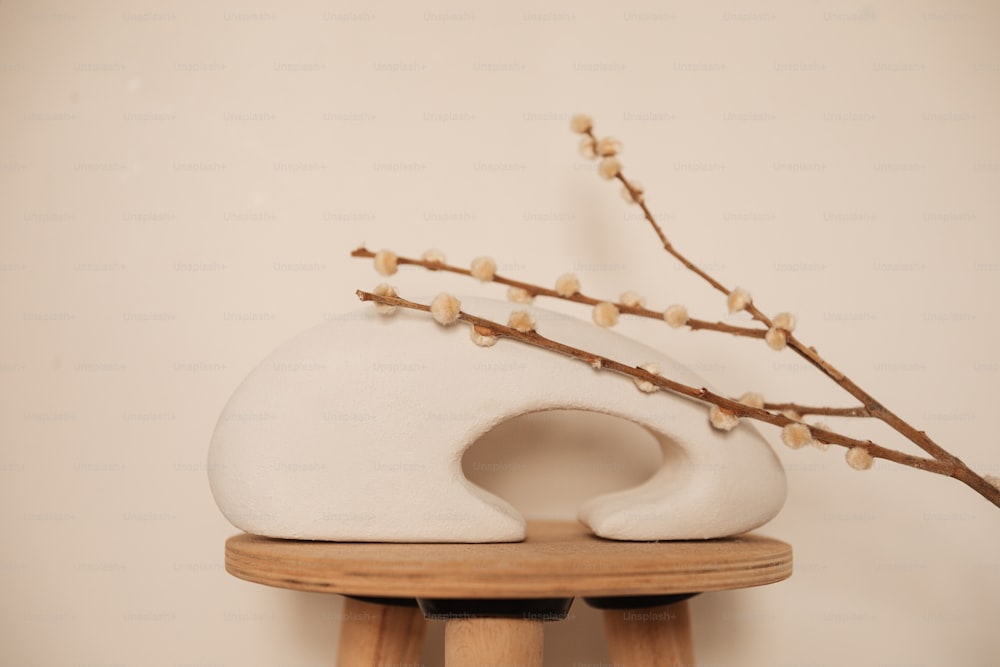 Un jarrón blanco sentado encima de una mesa de madera