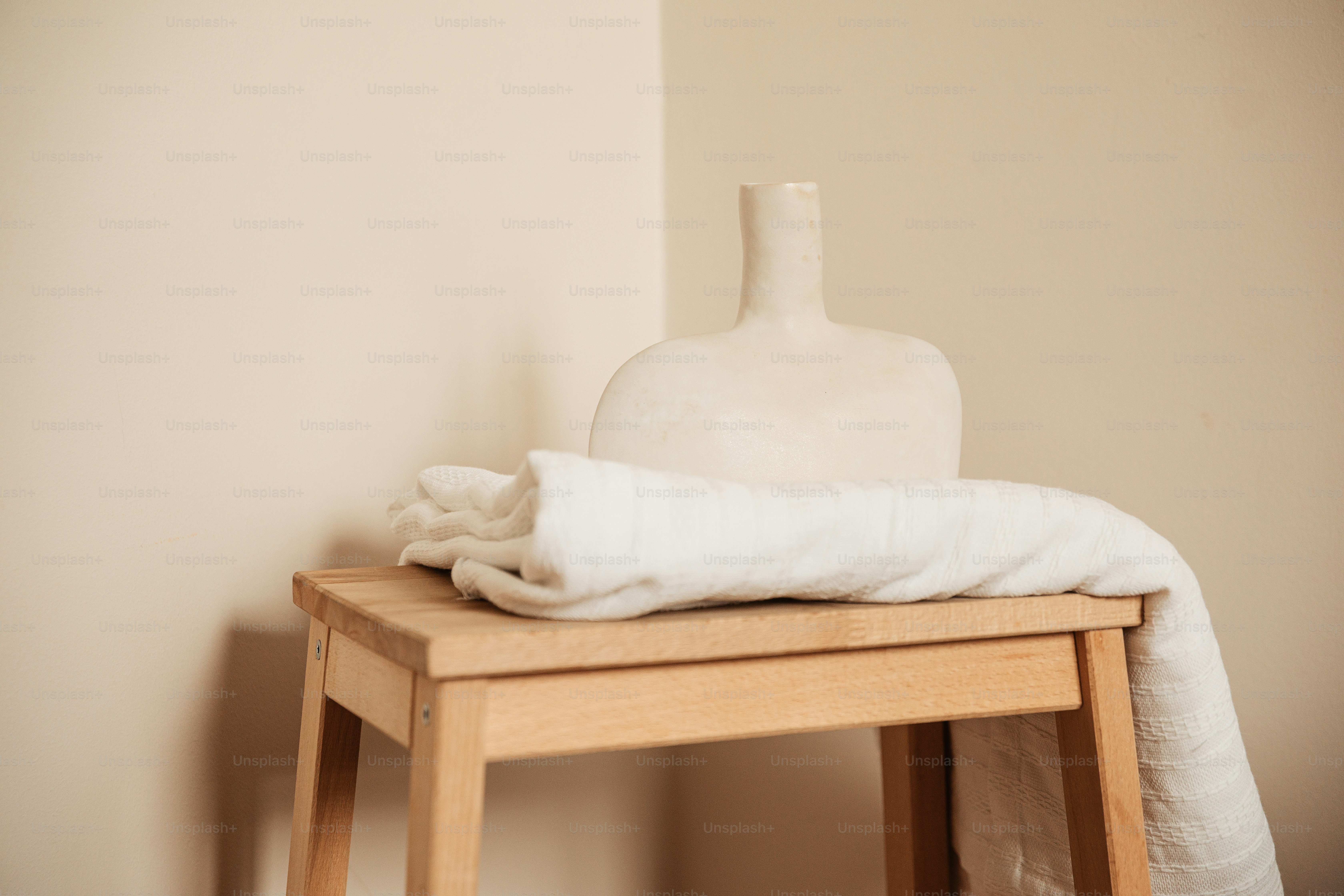 A white vase sitting on top of a wooden table photo – Interior design ...