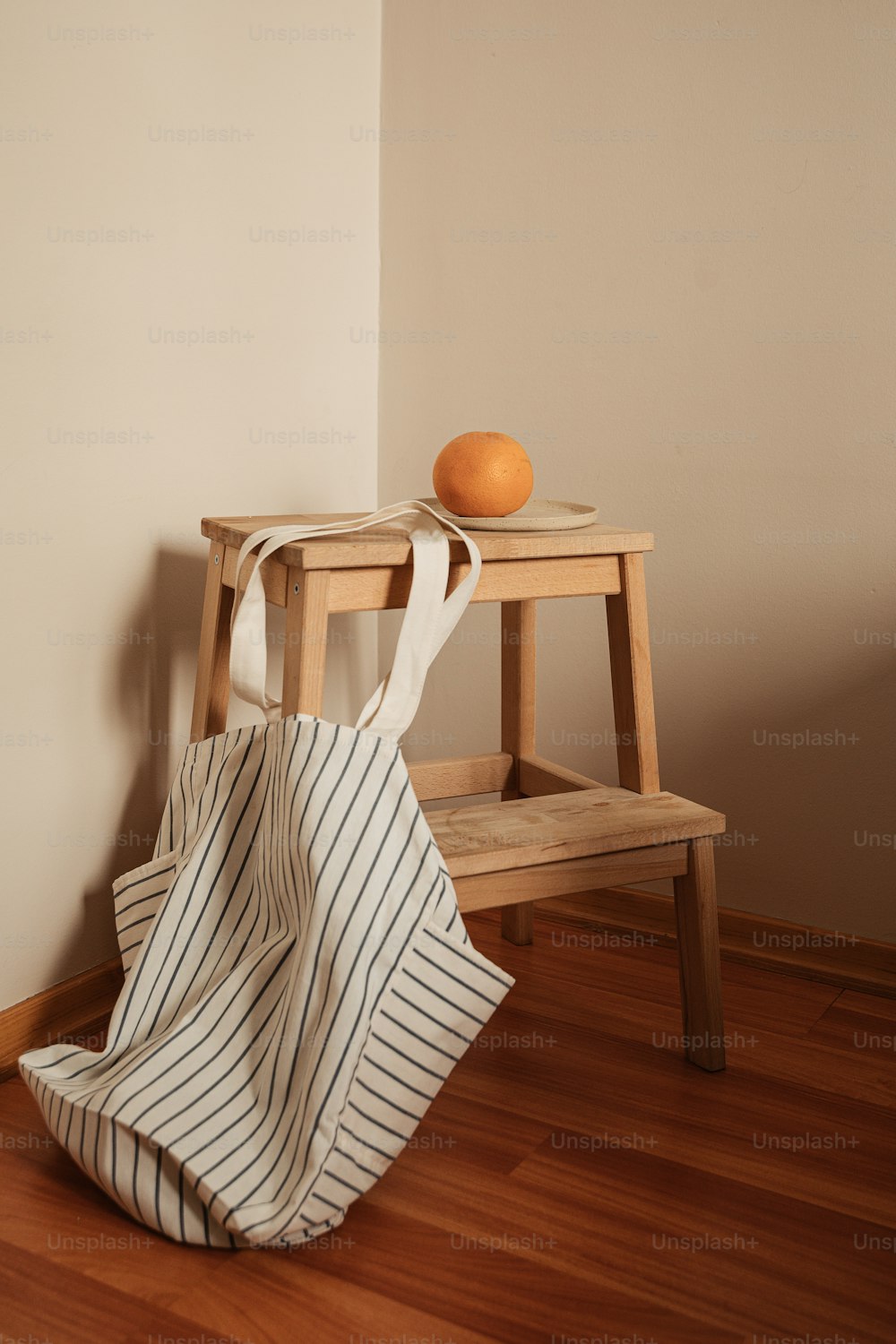 uma laranja sentada em cima de um banquinho de madeira
