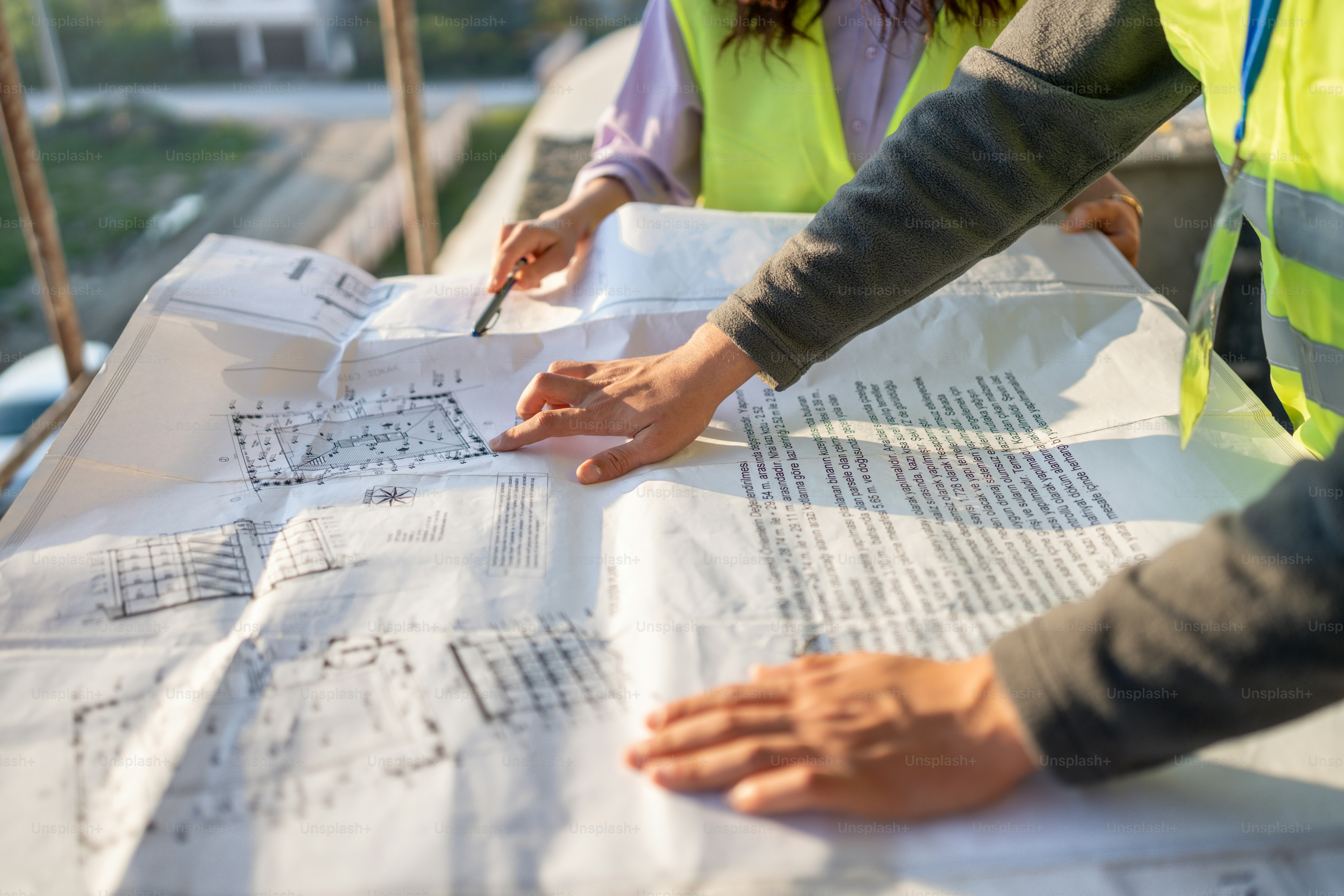 a couple of people standing over a large piece of paper