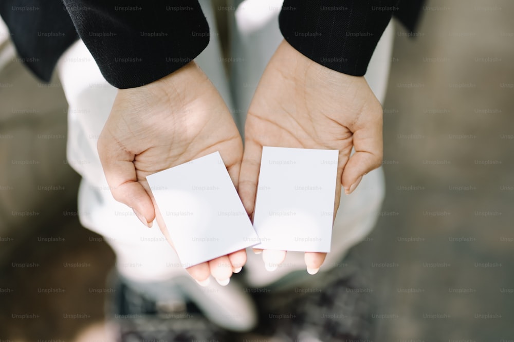 a person holding two cards in their hands