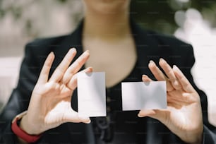a woman holding two cards in her hands