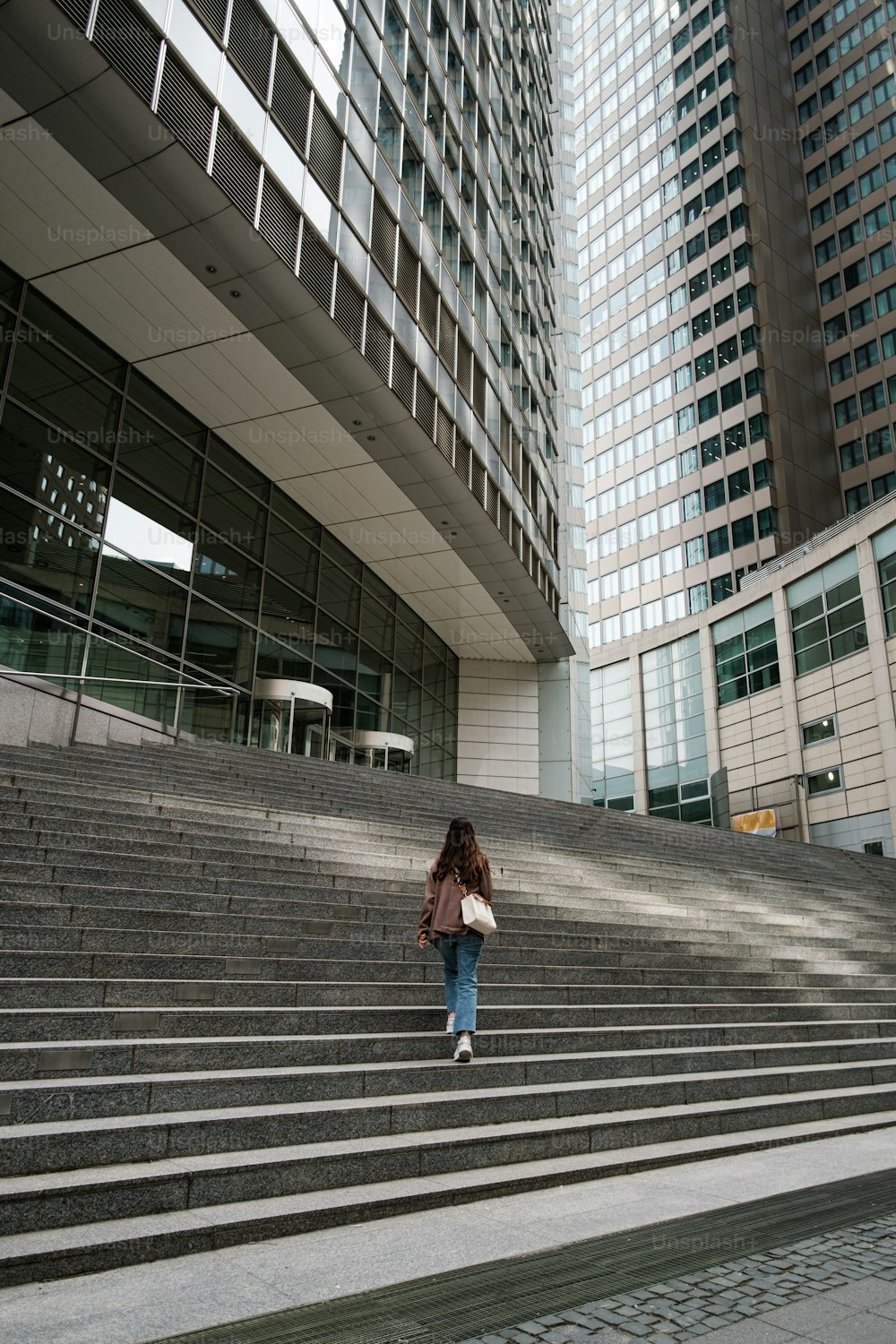 a woman walking up some steps in front of a building