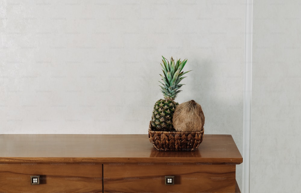 a pineapple sits on top of a wooden dresser