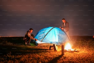 a group of people sitting around a campfire