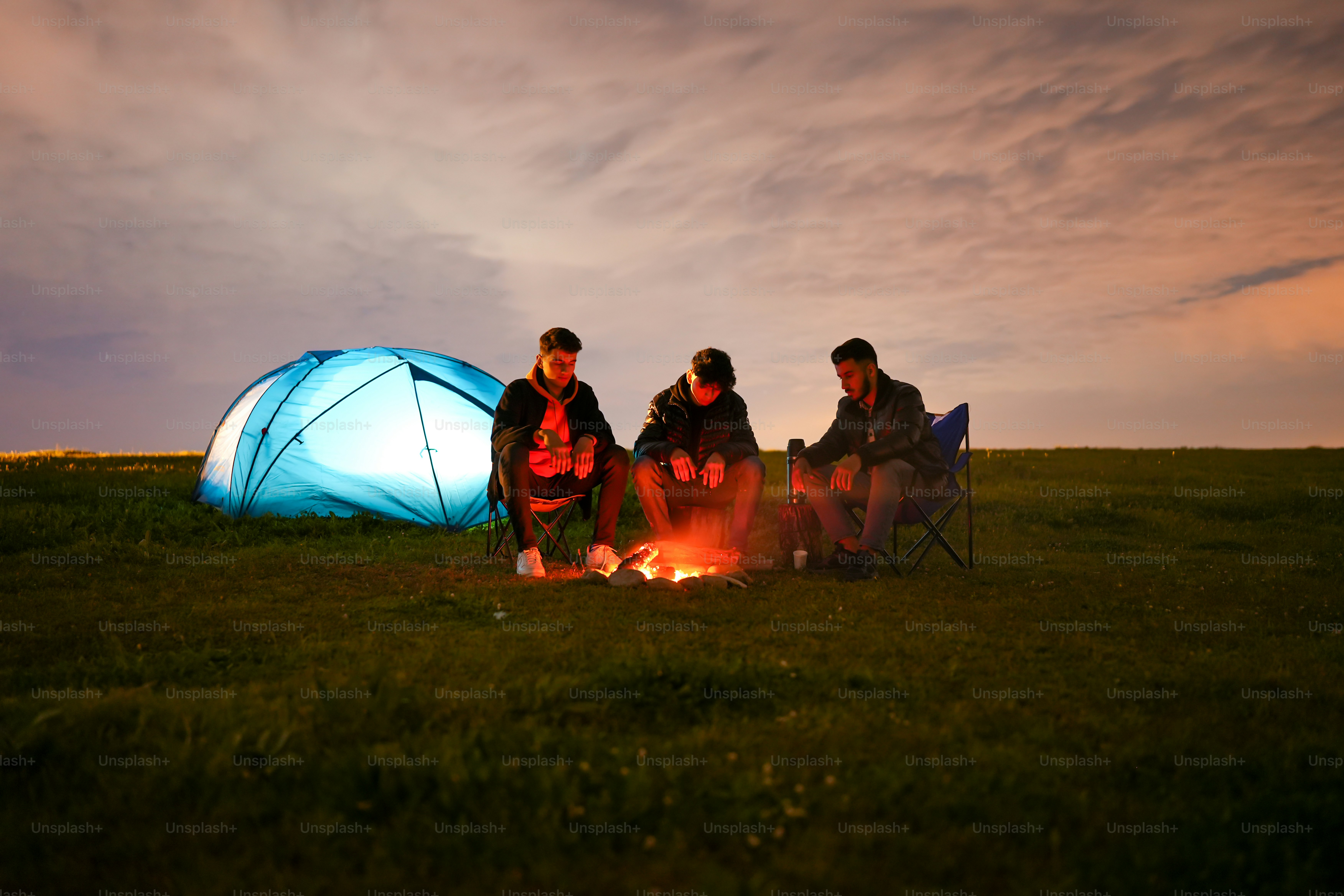 a group of people sitting around a campfire