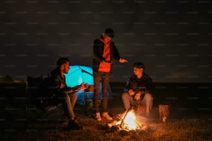 a group of people sitting around a campfire